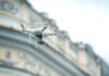 Dron quadcopter unosi się nad klasycznym budynkiem w Korei Północnej
