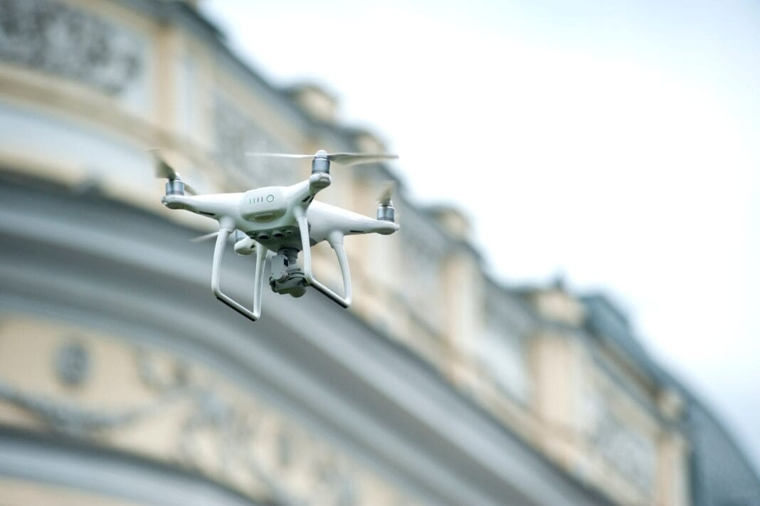 Dron quadcopter unosi się nad klasycznym budynkiem w Korei Północnej Dron quadcopter unosi się nad klasycznym budynkiem w Korei Północnej