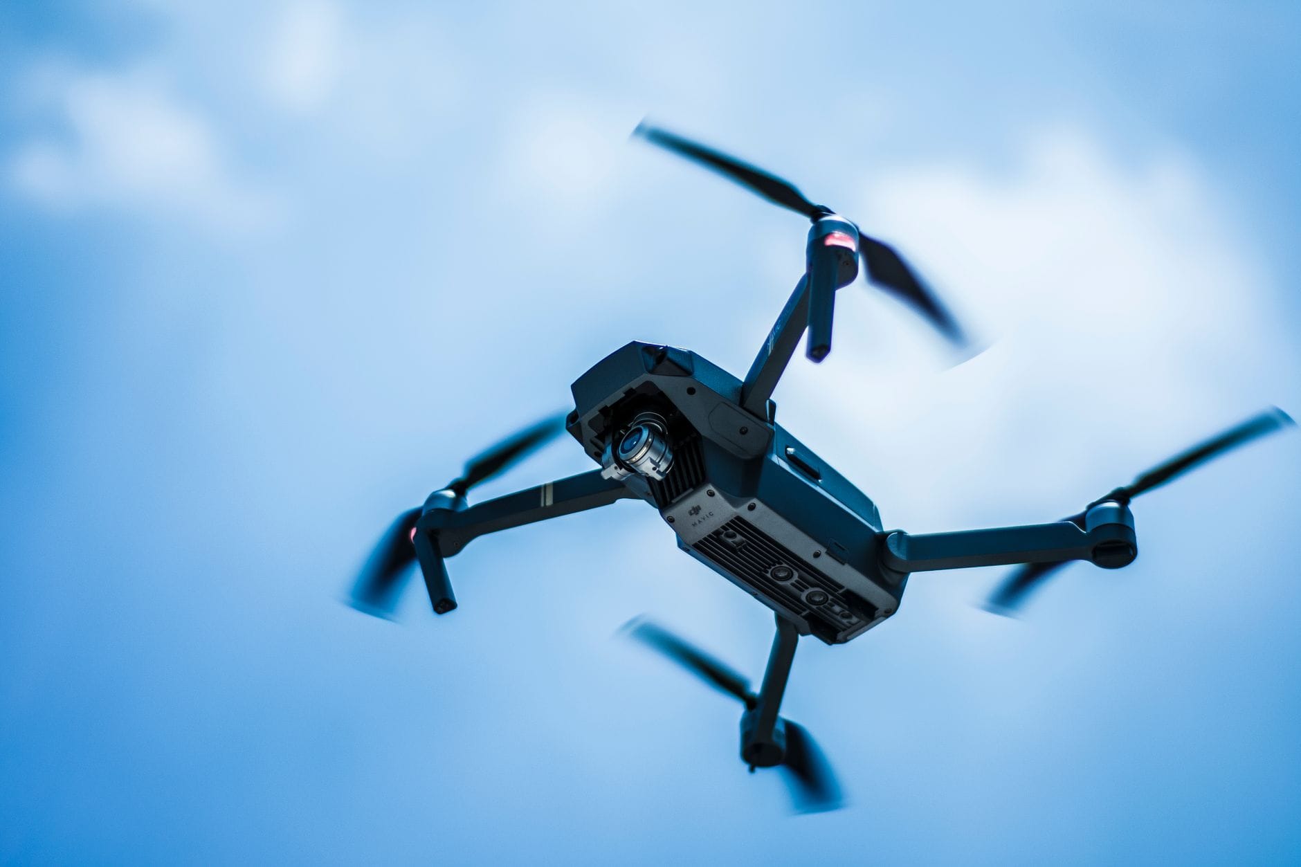 Nowoczesny dron na tle czystego, błękitnego nieba