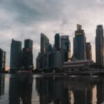 Panorama Singapuru o zmierzchu odbijająca się w wodzie przy nabrzeżu