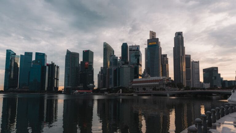 Panorama Singapuru o zmierzchu odbijająca się w wodzie przy nabrzeżu