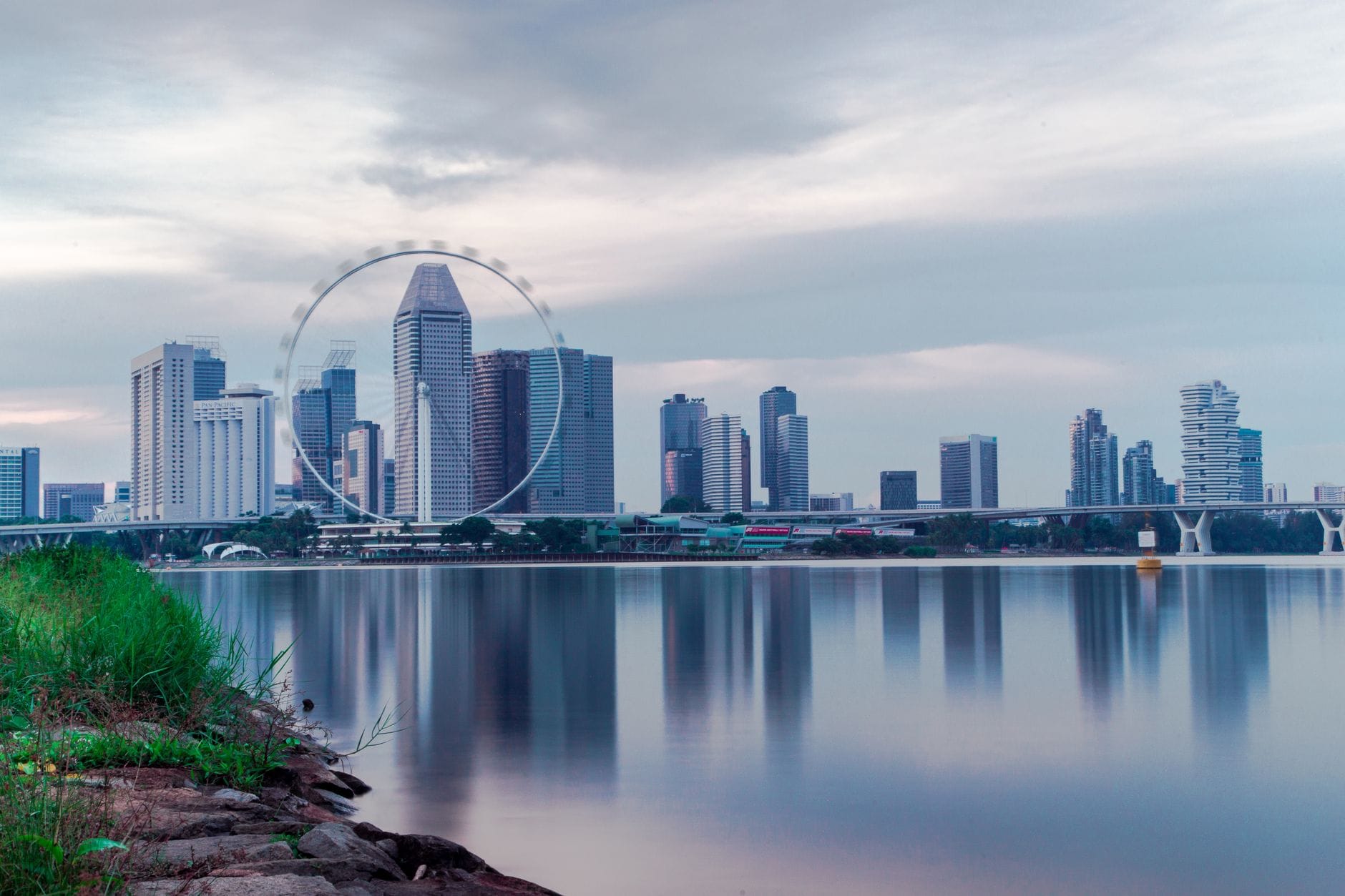 Panorama Singapuru z diabelskim młynem Singapore Flyer nad wodą