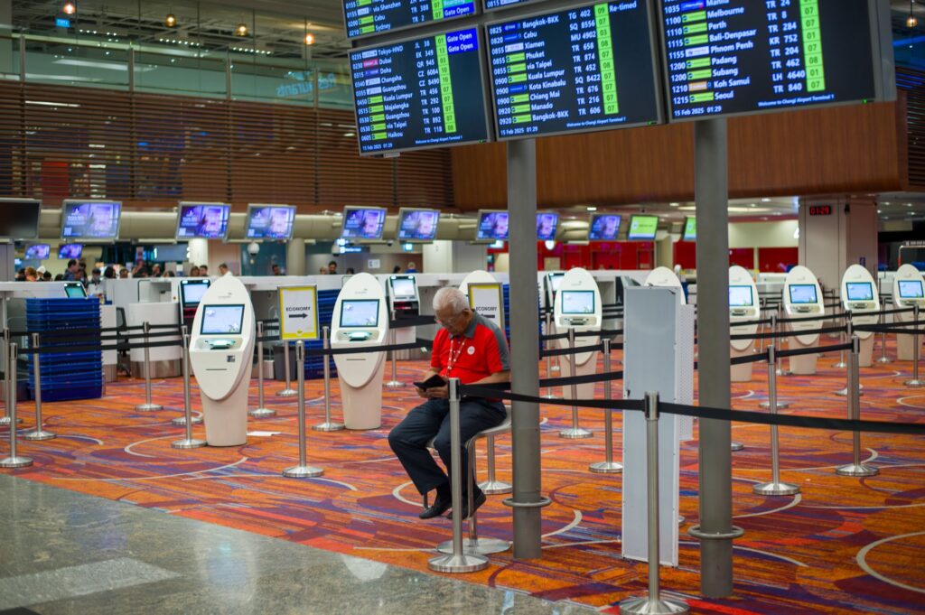 Terminal lotniska z tablicami lotów i kioskami odprawy